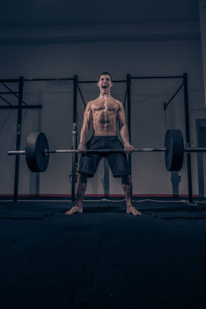 istock bodybuilder muscular deadlift, dark indoors gym, shouting screaming 675452236