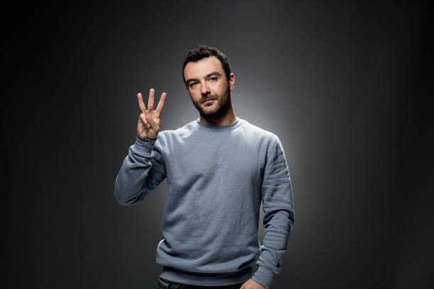 istock Young Man Showing Number Three with Fingers 675455208