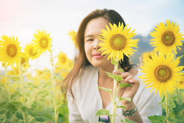 istock Sunflower and a woman hiding behind it 675459002