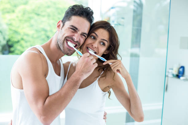 istock Young couple brushing teeth while standing in bathroom 675462768
