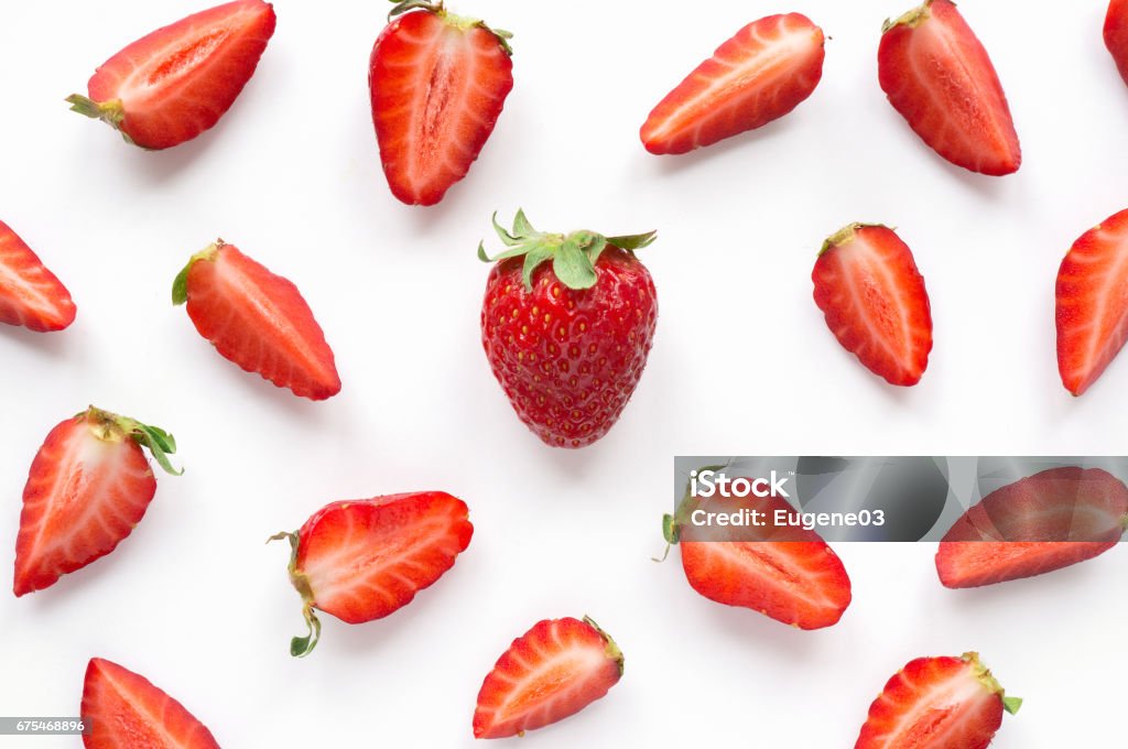 Strawberry creative pattern. Isolated food backdrop. Sliced and whole ripe red berries with green leaves on white background. Strawberry Stock Photo