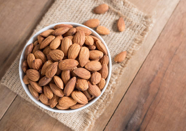 istock Almond in white bowl on wooden table 675471938