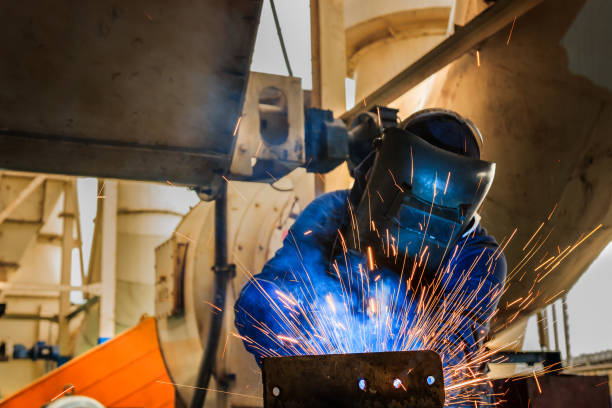 istock industrial worker is welding assembly part in factory 675472276