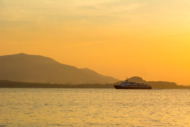 istock passenger boat with orange sunset 675481924