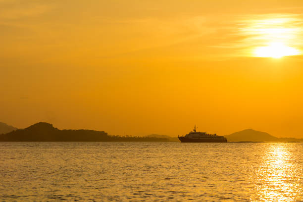 istock passenger boat with orange sunset 675481930