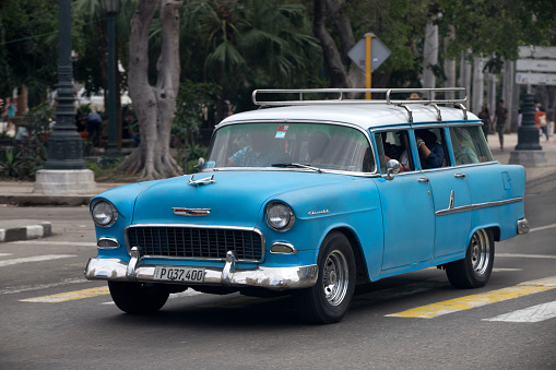 January, 28. 2017. Vintage cars are driving on the street. Incidental people on the background.