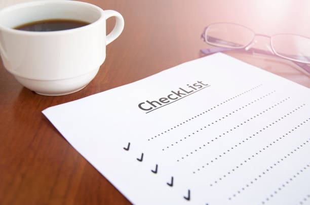 istock blank checklist on wooden table With coffee and glasses 675491700