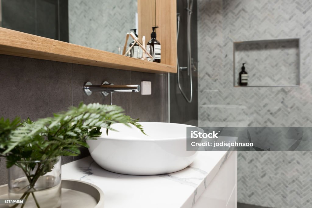 Bathroom details clean white basin with shower tiling behind Bathroom details clean white basin with herringbone marble mosaic shower tiling behind Bathroom Stock Photo