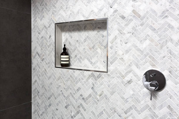 Shower shelf detail in wall of herringbone marble tiles stock photo