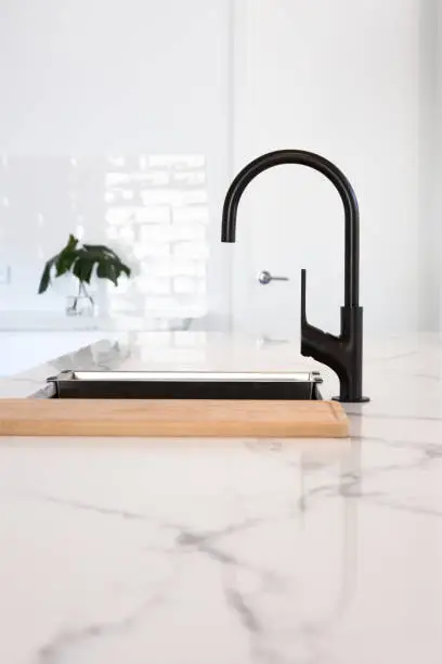 Goose neck black tapware in a stunning white kitchen with marble bench top
