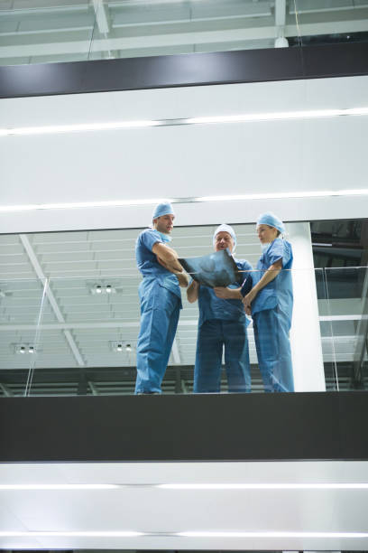 istock Team of surgeons discussing x-ray in corridor 675498650
