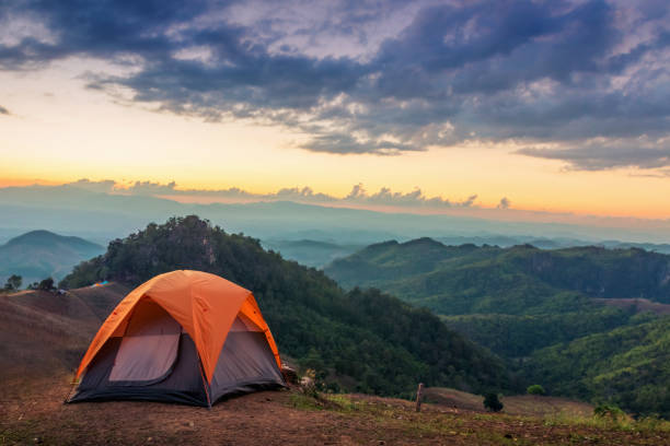 istock Tent on the hill beneath the mountains under dramatic sky 675501434