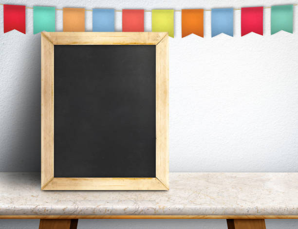 istock Blank blackboard and colorful flag banner on marble table at white wall,Leave space for display or montage of your design 675501792