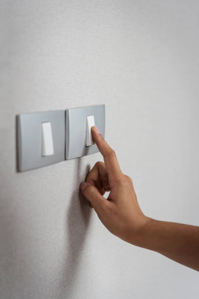 istock Close up hand turning on or off on grey light switches with texture background. Copy space. 675521776