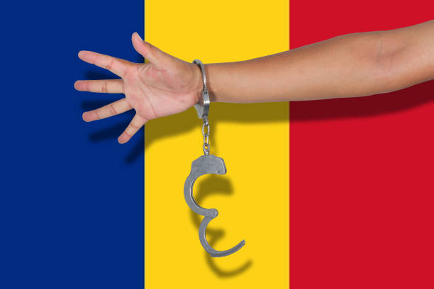 istock handcuffs with hand on Romania flag 675522596
