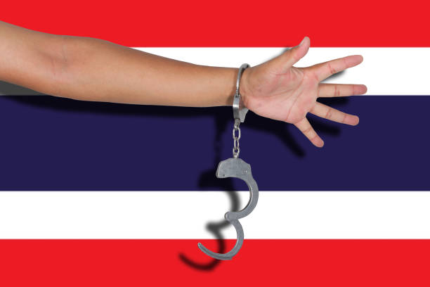 istock handcuffs with hand on Thailand flag 675523372