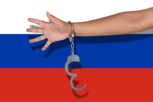 istock handcuffs with hand on Russia flag 675523436