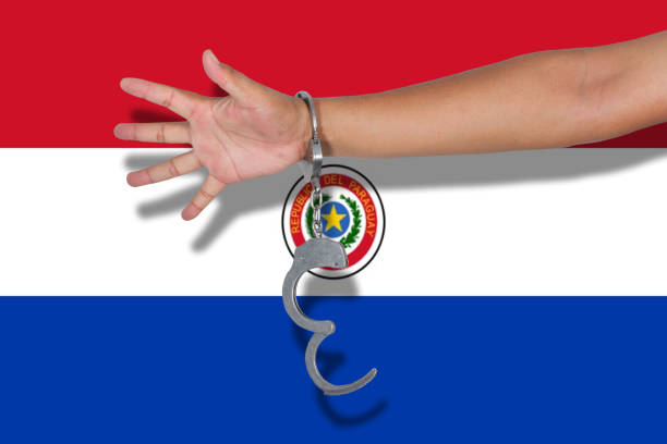 istock handcuffs with hand on Paraguay flag 675525718