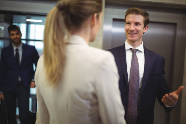 istock Businessman interacting with his female colleague near elevator 675529702