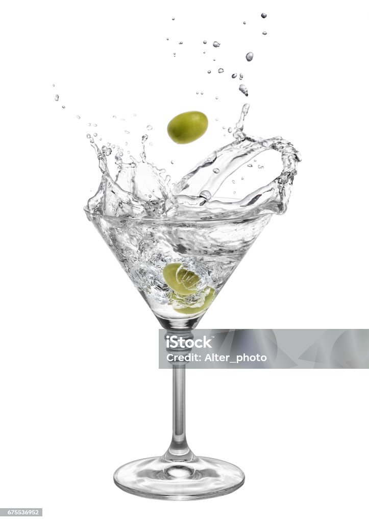 martini with olives and splashes martini in glass with splashes and olives isolated on white background. Green olive is falling in the alcohol cocktail. Splash of martini from the falling olives Martini Stock Photo