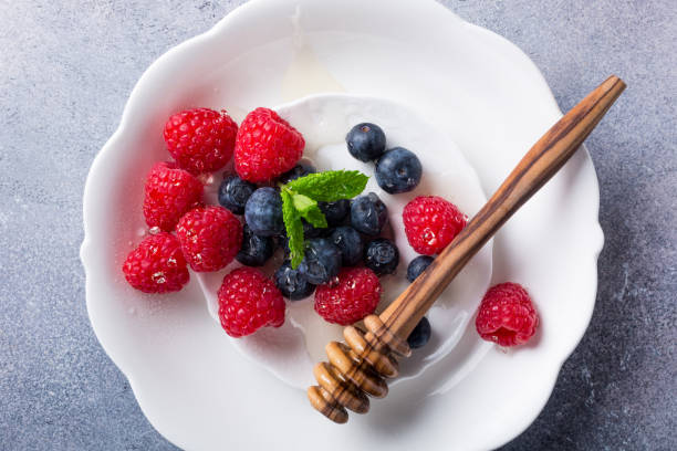 istock Freshly picked blueberries and raspberries on white plate 675541082