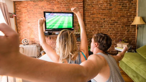 istock couple watching the match on tv 675543656