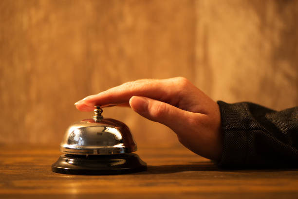istock Businesswoman ringing hotel reception bell 675550016