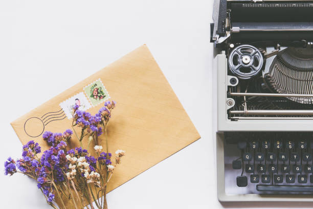 Top view of dry flowers, typewriter and mail envelope