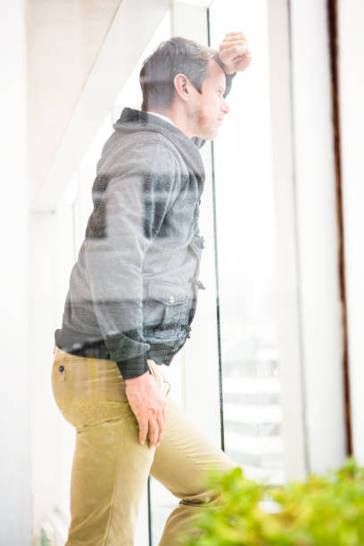 istock Thoughtful businessman leaning on glass window 675557450
