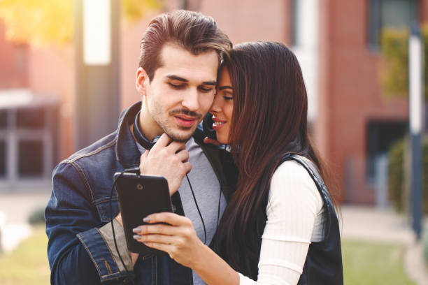 istock Young couple sharing music on tablet outdoor 675560138