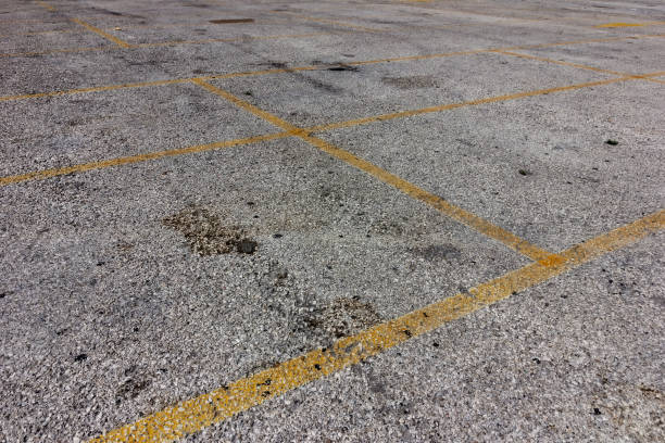 istock yellow lines on dirty bright asphalt 675560560