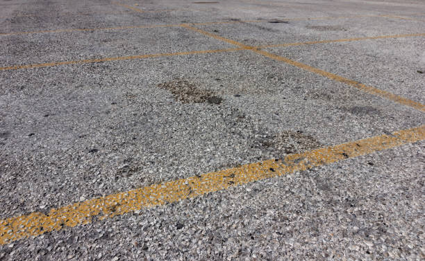 istock yellow lines on dirty bright asphalt 675560644