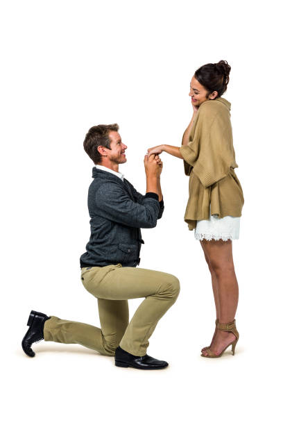istock Handsome man proposing beautiful woman while kneeling 675570494