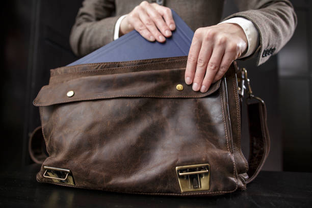 istock teacher in a jacket gets a book from an old leather briefcase 675579682