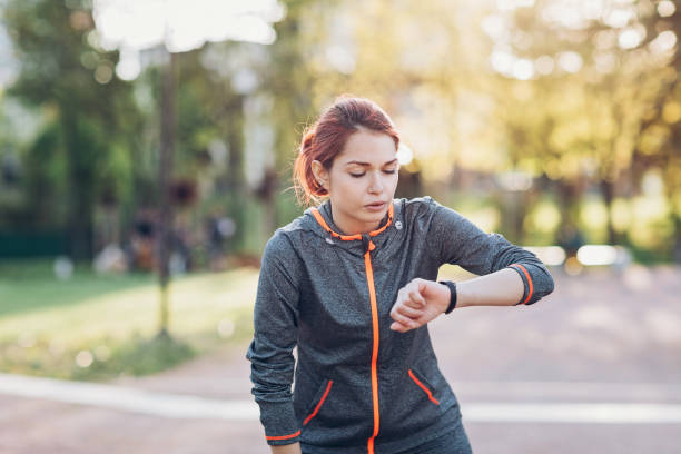 istock Sportswoman taking break and checking her smart watch 675579792