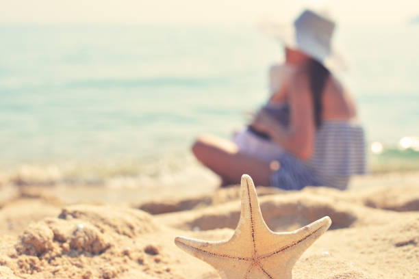 istock Mother and baby on the seaside with starfish 675580052