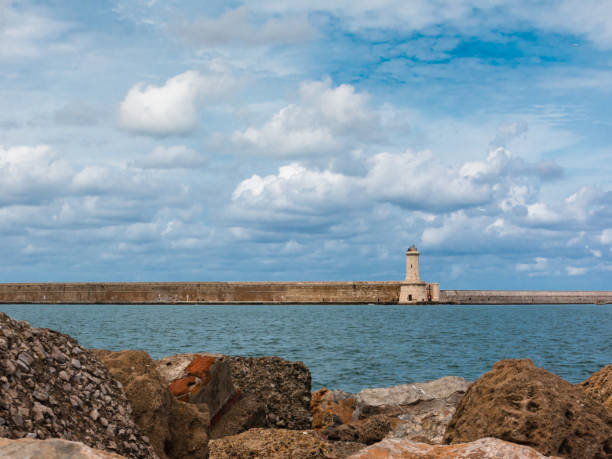istock Tuscany Coastline: White Lighthouse Tower, Cliffs and Stone Jetty near Sea, Italy 675580142