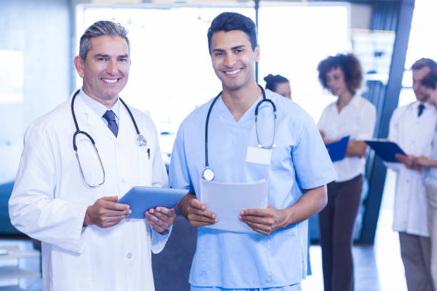 istock Doctors with digital tablet and medical report looking at camera and smiling 675586470