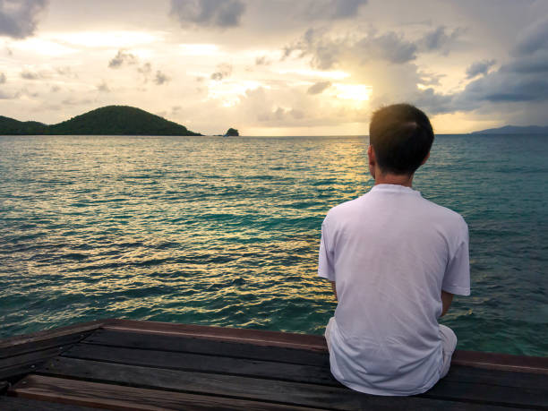 istock silhouette of thinking man on bench by sunset 675594100