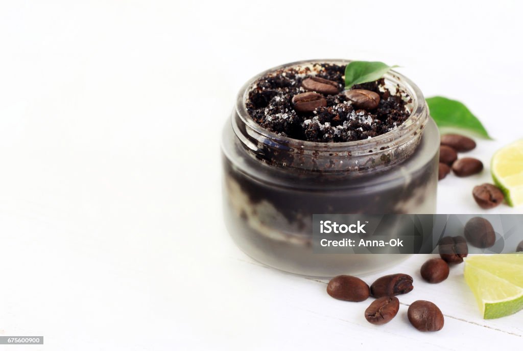 Cosmetic matte glass jar of coffee grounds natural scrub mixed with sugar beans and lime scented. Side copyspace. Coffee Crop Stock Photo