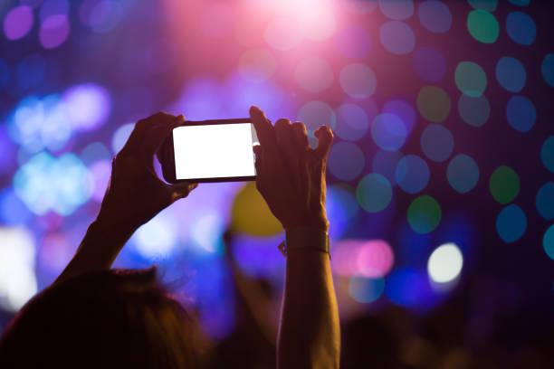 istock Hand with a smartphone records luxury party with blank white screen 675606770