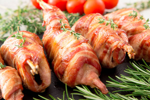 istock baked quail wrapped in bacon on a slate board 675609456