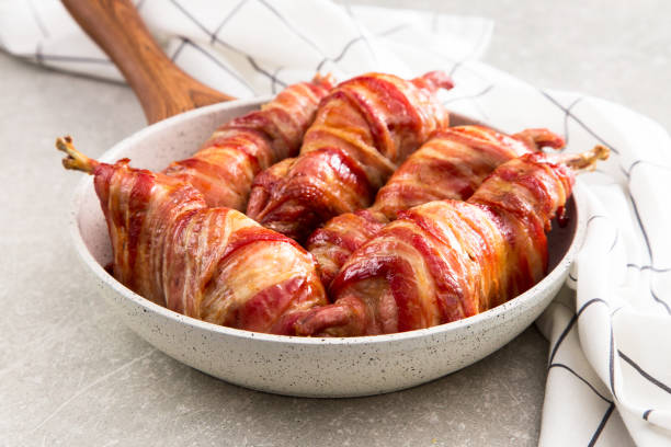 istock baked quail wrapped in bacon on a slate board 675609612