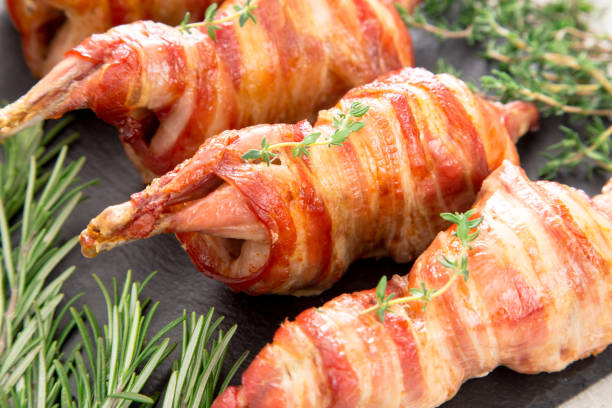 istock baked quail wrapped in bacon on a slate board 675612212