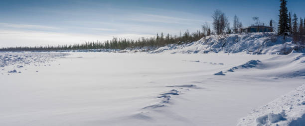 lone house on the banks of the frozen mackenzie river - inuvik imagens e fotografias de stock