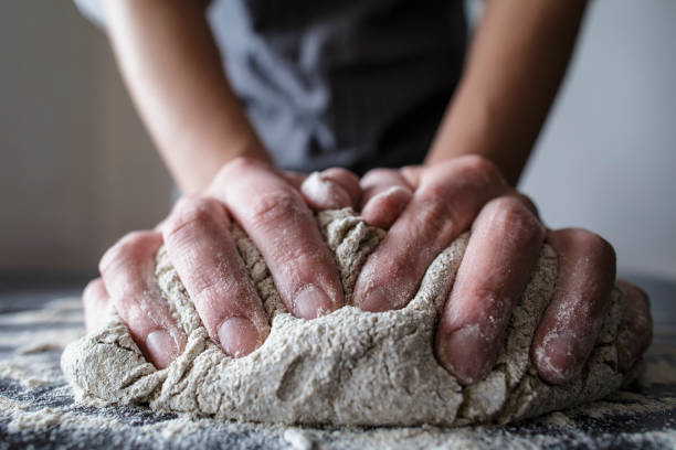 istock human hands knead the dough on a black wooden table 675631546