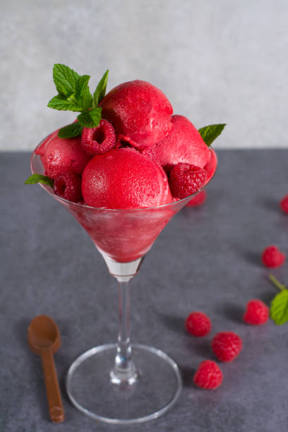 istock Raspberry ice cream sorbet in glass with chocolate spoon, raspberry, mint leaves  copy space 675638086