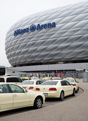 Munich, Germany - 22 April 2017: Taxis are queueing up in the rain outside the Allianz Arena football stadium in Munich, Germany. With 75'000 seats, Allianz Arena is one of Germany's largest sports stadiums and home of FC Bayern Munich.