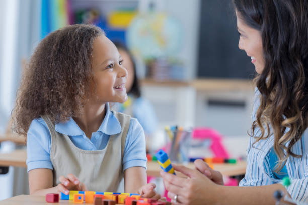 istock Happy preschool student talks with teacher 675639020