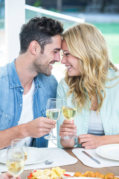 istock Romantic couple holding white wine glasses 675642384